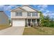 Two-story home featuring stone accents, a two-car garage, and a well-manicured lawn at 347 Carolina Hemlock Dr, Locust, NC 28097