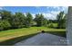 Spacious backyard with lush green lawn and a view of the trees and sky from a concrete patio at 347 Carolina Hemlock Dr, Locust, NC 28097