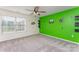 Bright bedroom with a window, neutral carpet, and a vibrant green accent wall with decals provides unique charm at 347 Carolina Hemlock Dr, Locust, NC 28097