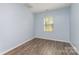 Bright bedroom with light-blue walls, wood-look floors and a window at 347 Carolina Hemlock Dr, Locust, NC 28097