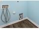 Laundry room featuring wood floors, blue walls, and washing machine hook ups at 347 Carolina Hemlock Dr, Locust, NC 28097