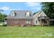 A spacious backyard featuring a well-maintained lawn and a charming two-story home with a brick and tan siding exterior at 5111 Clearwater Rd, Charlotte, NC 28217