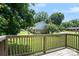 Lush backyard view from a wooden deck with a green lawn and mature trees at 5111 Clearwater Rd, Charlotte, NC 28217