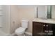 Bathroom featuring toilet, shower, and sink with wood vanity and light countertop at 5111 Clearwater Rd, Charlotte, NC 28217
