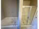 Bright bathroom features a soaking tub and separate glass-enclosed shower at 5111 Clearwater Rd, Charlotte, NC 28217