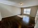 A bright bedroom featuring hardwood floors and a large window that let in natural light at 5111 Clearwater Rd, Charlotte, NC 28217