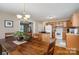 Kitchen flows into dining area with wood floors, a dining table, and warm lighting at 5111 Clearwater Rd, Charlotte, NC 28217