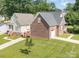 An aerial view showcasing the exterior of the home, highlighting its brick and siding accents and well-manicured lawn at 5111 Clearwater Rd, Charlotte, NC 28217
