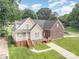 Inviting front view of a two-story home with wood deck, landscaped yard, and paved driveway on a sunny day at 5111 Clearwater Rd, Charlotte, NC 28217