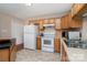 Practical kitchen design featuring tile floors, white appliances, wood cabinets, and an efficient layout for cooking at 5111 Clearwater Rd, Charlotte, NC 28217