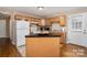 Well-lit kitchen features wood cabinetry, white appliances, a functional layout, and a center island for added convenience at 5111 Clearwater Rd, Charlotte, NC 28217