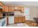 Functional kitchen features wood cabinets, white appliances, and ample counter space, providing a practical culinary area at 5111 Clearwater Rd, Charlotte, NC 28217