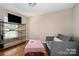 Comfortable living area with hardwood floors, a sofa, and a wall-mounted TV at 5111 Clearwater Rd, Charlotte, NC 28217
