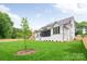 Expansive backyard featuring a well-manicured lawn, mature trees, and a charming white brick facade at 5127 Lansing Dr, Charlotte, NC 28270