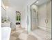 Bathroom featuring glass enclosed shower, standalone tub, stylish vanity and checkered floors with bedroom view at 5127 Lansing Dr, Charlotte, NC 28270
