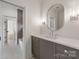 Bathroom featuring gray cabinets, a modern mirror, and a view into the shower/tub at 5127 Lansing Dr, Charlotte, NC 28270