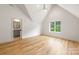 Bright bedroom with hardwood floors, a large window, and a vaulted ceiling, offering a view of the bathroom at 5127 Lansing Dr, Charlotte, NC 28270