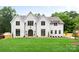 Stunning white brick home featuring a manicured lawn, arched entry and well-placed landscaping at 5127 Lansing Dr, Charlotte, NC 28270