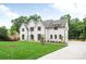 Stately white brick home with a sprawling lawn, mature trees, and a circular driveway at 5127 Lansing Dr, Charlotte, NC 28270