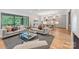 Open-concept living room features a glass coffee table, comfortable sofas, and kitchen in background at 5127 Lansing Dr, Charlotte, NC 28270