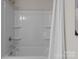 Clean white bathtub and shower combination with grab bar and white shower curtain at 5481 Comiskey Aly, Kannapolis, NC 28081