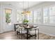 Sunny dining room featuring a modern table set, contemporary lighting, and a bright view through shuttered windows at 5481 Comiskey Aly, Kannapolis, NC 28081