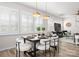 Dining room with a modern table set and gold pendant lights, illuminated by natural light through shuttered windows at 5481 Comiskey Aly, Kannapolis, NC 28081