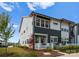 A beautifully landscaped townhome showcases a well-manicured lawn, a white picket fence, and a modern architectural style at 5481 Comiskey Aly, Kannapolis, NC 28081
