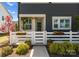 Inviting entryway with a charming white picket fence, blooming flowers, and lush greenery enhance this home's curb appeal at 5481 Comiskey Aly, Kannapolis, NC 28081