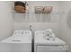 Bright laundry room with side by side washer and dryer and overhead storage at 5481 Comiskey Aly, Kannapolis, NC 28081