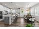 Spacious open concept kitchen and dining area with modern furnishings and bright natural light from shuttered windows at 5481 Comiskey Aly, Kannapolis, NC 28081