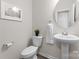 Clean, well-lit powder room featuring a pedestal sink, toilet, and modern fixtures, with neutral tones at 5481 Comiskey Aly, Kannapolis, NC 28081