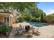 A well-manicured backyard featuring a pool, patio with seating, and mature trees at 640 Colville Rd, Charlotte, NC 28207
