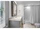 Bright bathroom with a marble countertop, shuttered window, and a combined shower and tub at 640 Colville Rd, Charlotte, NC 28207