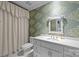 Charming bathroom featuring green wallpaper, decorative mirror, and a white vanity for a fresh look at 640 Colville Rd, Charlotte, NC 28207