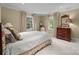 Elegant bedroom with neutral tones, natural light from two windows, and classic wooden dresser at 640 Colville Rd, Charlotte, NC 28207