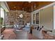 Cozy outdoor living space with a stone fireplace, brick flooring, and comfortable seating at 640 Colville Rd, Charlotte, NC 28207