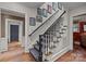 Elegant stairway with patterned carpet, white railings, and decorative artwork along the wall at 640 Colville Rd, Charlotte, NC 28207