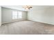 Spacious bedroom with carpet, a ceiling fan, and a large window providing natural light at 673 Shellbark Dr, Concord, NC 28025