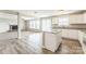 Bright and airy kitchen flowing into the living room, with white cabinetry, a center island, and wood-look flooring at 673 Shellbark Dr, Concord, NC 28025