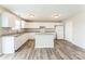 Bright kitchen featuring white cabinetry, a center island, modern appliances, and wood-look flooring at 673 Shellbark Dr, Concord, NC 28025