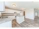 Bright kitchen with white cabinetry, a center island, modern appliances, and wood-look flooring at 673 Shellbark Dr, Concord, NC 28025