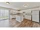 Bright kitchen with white cabinetry, a center island, modern appliances, and wood-look flooring at 673 Shellbark Dr, Concord, NC 28025