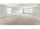 Expansive living room with plush carpeting and abundant natural light from multiple large windows at 673 Shellbark Dr, Concord, NC 28025