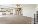 Open-concept living space showcasing the living room, kitchen, and staircase, with plush carpeting at 673 Shellbark Dr, Concord, NC 28025