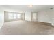 Spacious living room with carpet and large windows, perfect for entertaining or relaxing at 673 Shellbark Dr, Concord, NC 28025