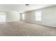 Large living room with carpet and windows providing ample natural light and access to the patio at 673 Shellbark Dr, Concord, NC 28025
