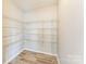 Spacious walk-in pantry with ample shelving and modern wood-look flooring for organized storage at 673 Shellbark Dr, Concord, NC 28025
