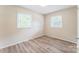 A bedroom has natural light from two windows and modern vinyl flooring at 711 September Ln, Charlotte, NC 28208