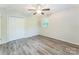 A bedroom with new floors has a window to let in natural light and a spacious closet at 711 September Ln, Charlotte, NC 28208